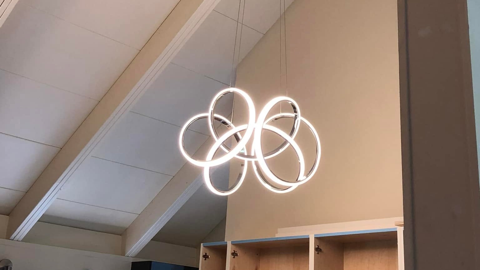 Modern ring pendant light fixture installed beneath a vaulted ceiling